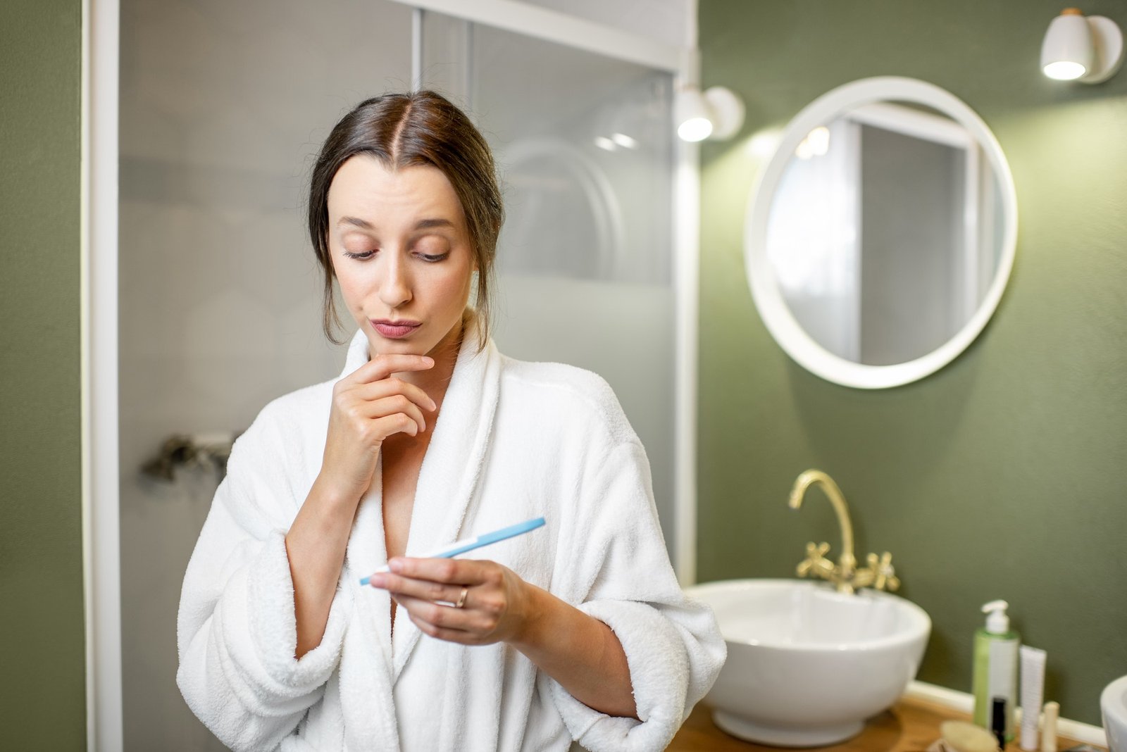 Worried woman wiwth pregnancy test in the bathroom